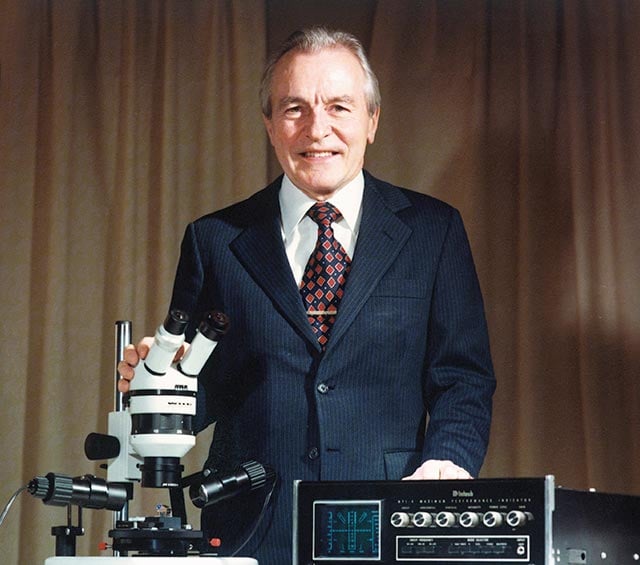 Gordon Gow, president from 1977, with the microscope he urged dealers to use to inspect phono styli